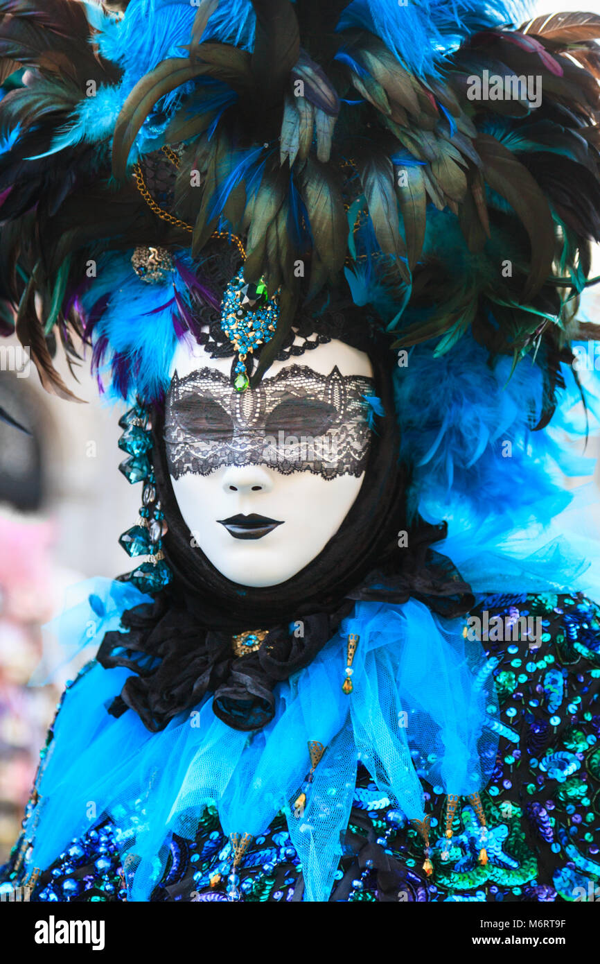 Woman in beautiful blue feather fancy dress costume and mask at the Venice Carnival, close up, Carnivale di Venezia, Veneto, Italy Stock Photo