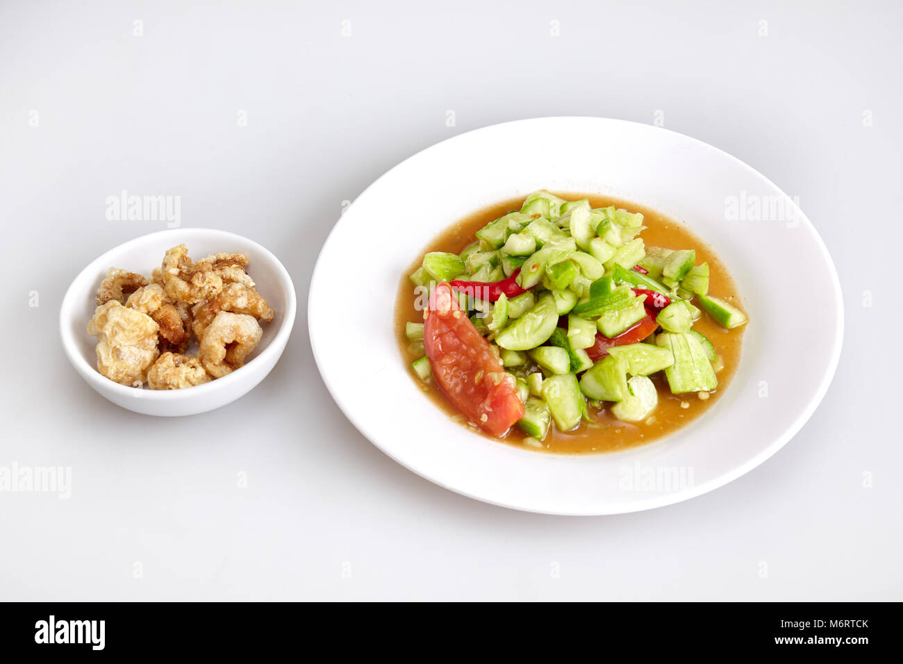 Thai traditional food, local food, cucumber spicy salad, Crispy pork skin on white background - top view Stock Photo