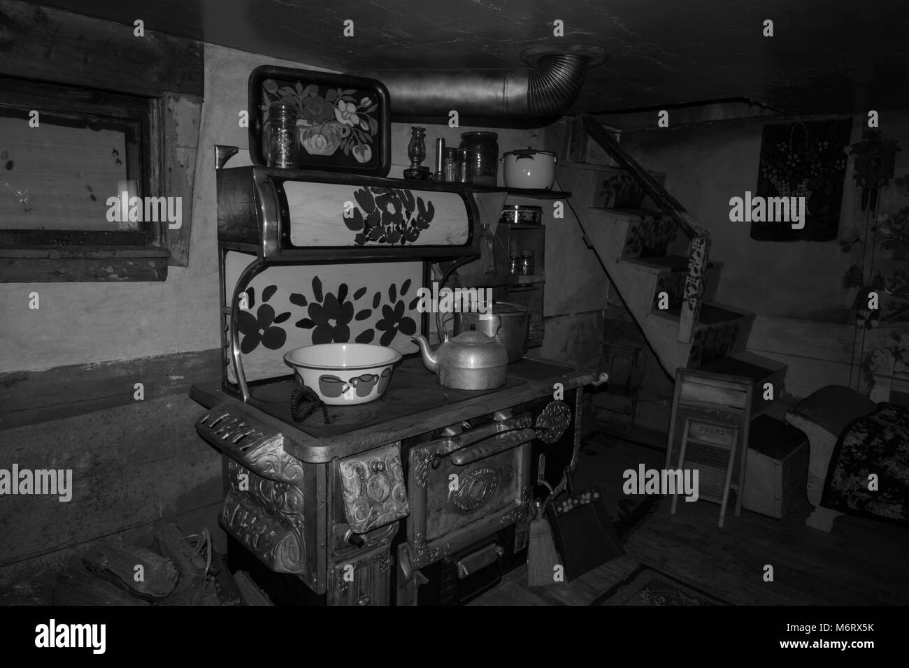 painted oven and pots also kettle in a museum Nova Scotia Halifax Maud Lewis house Canada black and white pots painting painted cat stairs bowl kettle Stock Photo