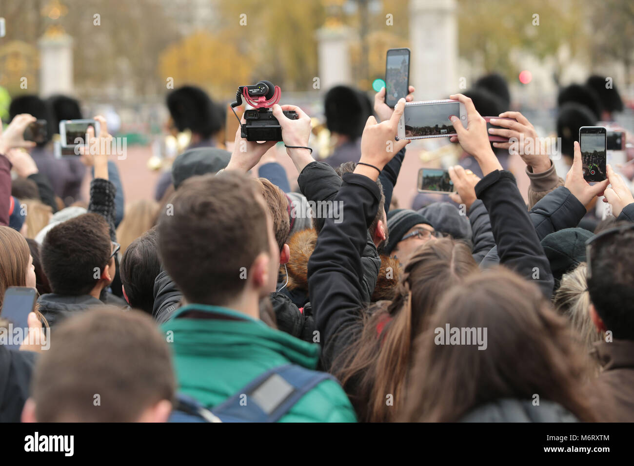 Tourists jostle for position to film the daily changing of the guard at Buckingham Palace London the home of Queen Elizabeth 11 Stock Photo