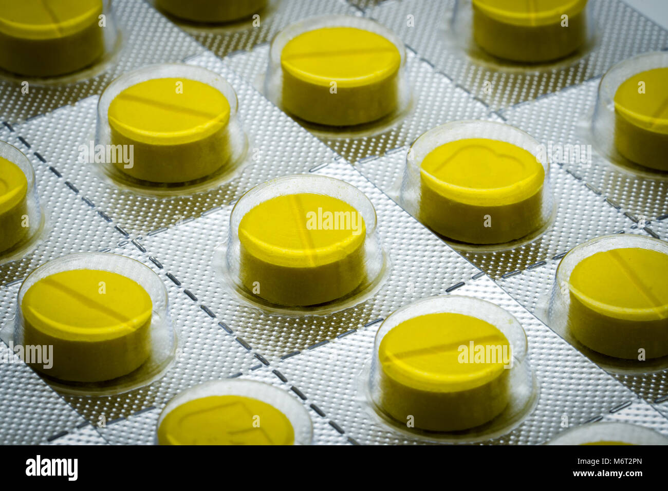 Macro shot detail of yellow tablets pill in blister pack. Full frame of tablet pills Stock Photo