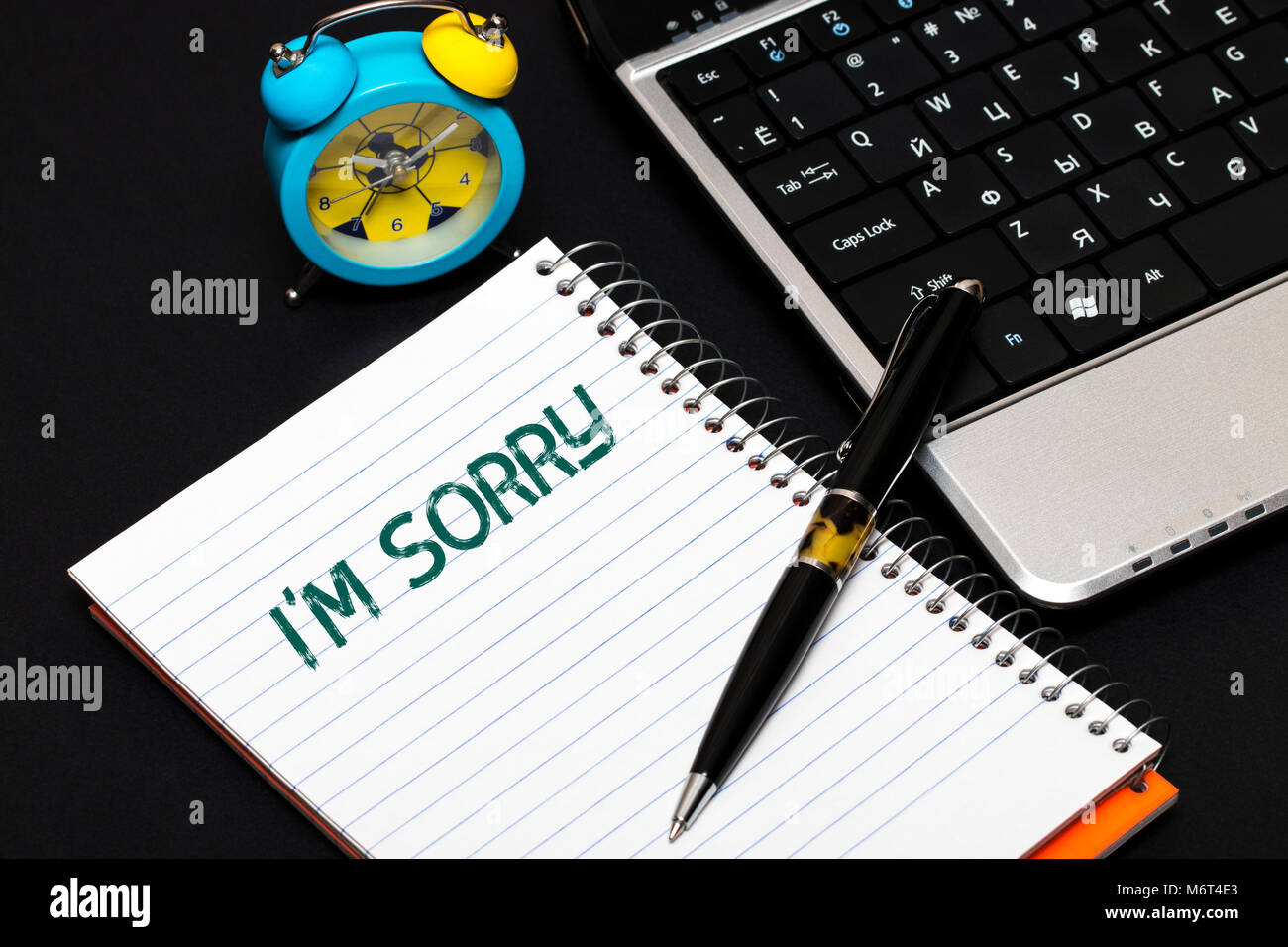 I'm sorry text concept write on notebook.alarm clock blue Stock Photo - Alamy