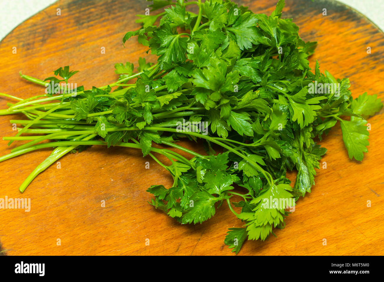 Organic italian parsley closeup on rustic wooden table, healthy vegetarian food. Stock Photo