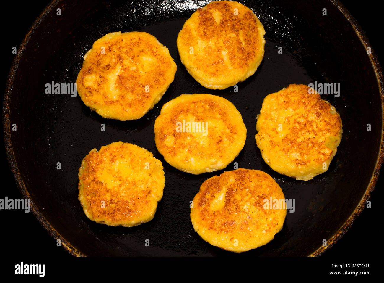 Fried curd cheese pancakes, cheesecakes in frying pan, close up view. Stock Photo