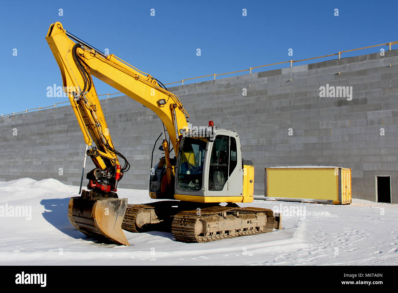 Yellow excavator on a construction site in winter Stock Photo - Alamy