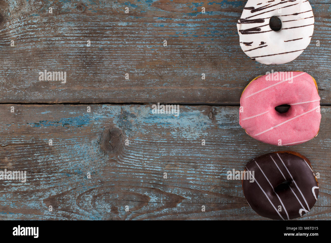 Donuts in a glaze assorted on a wooden table. Free space for text. Top ...