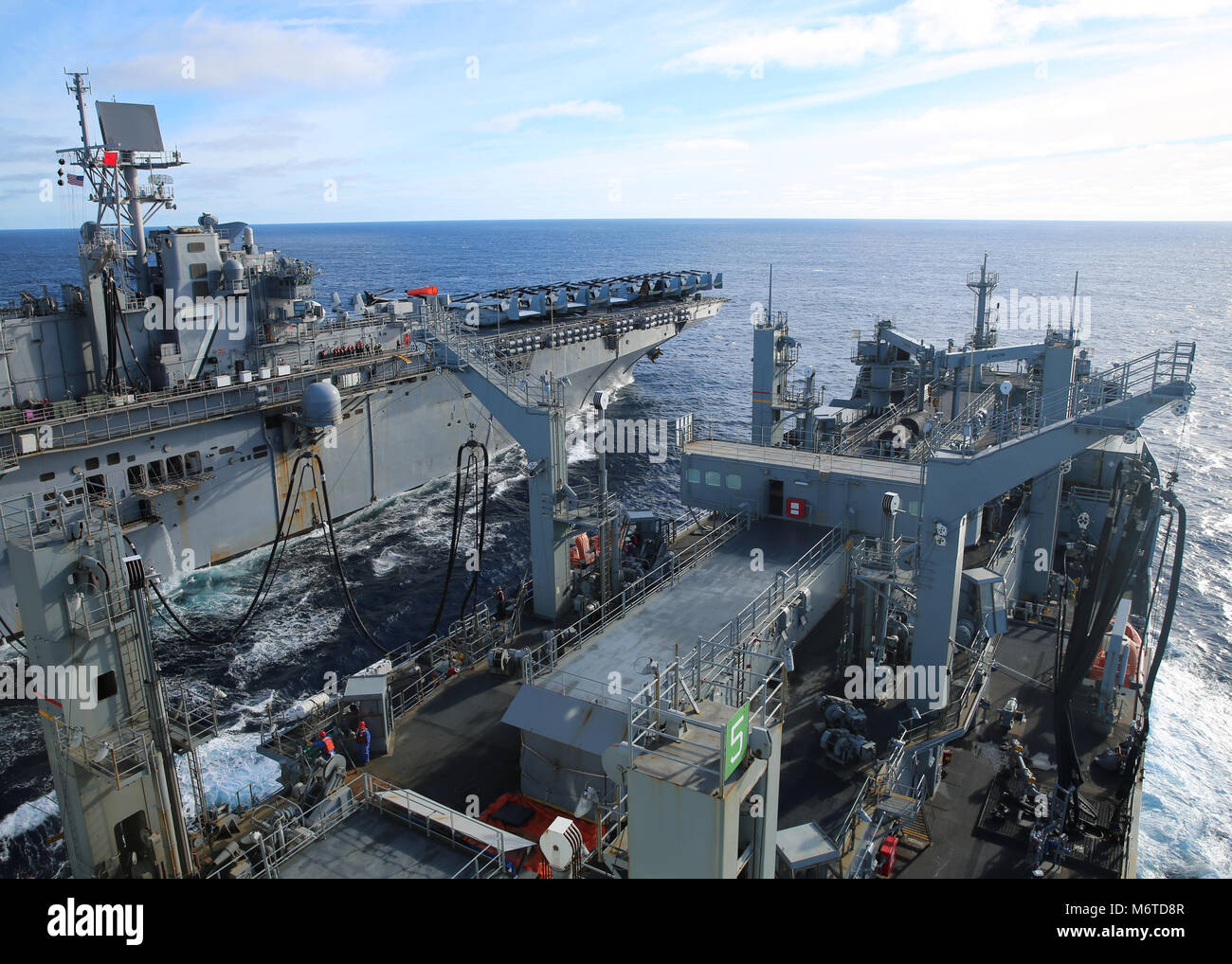 180215-N-OH262-609  ATLANTIC OCEAN (Feb. 15, 2018) The dry cargo and ammunition ship USNS Robert E. Peary (T-AKE 5) sends fuel to the amphibious assault ship USS Iwo Jima (LHD 7) during a replenishment-at-sea. (U.S. Navy photo by Bill Mesta/Released) Stock Photo