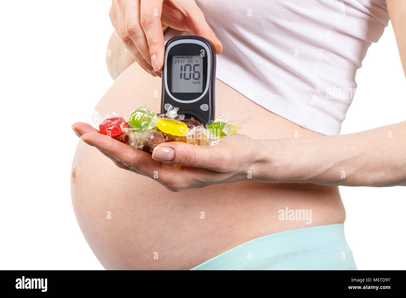 Pregnant woman holding colorful candies and with result of