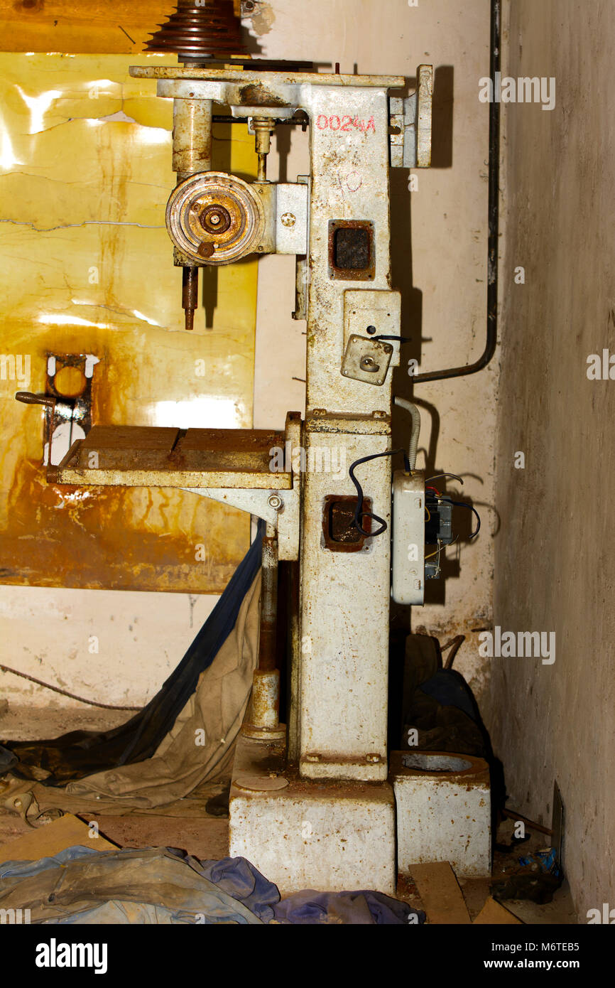 An old and rusty broken industrial machine in an abandoned and ...