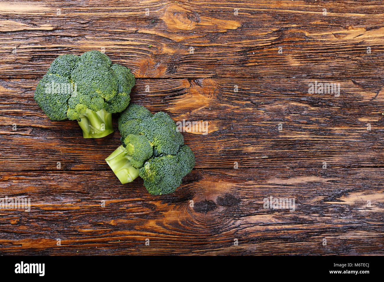 Inflorescence of raw broccoli on a wooden table, With space for text, horizontal shot Stock Photo