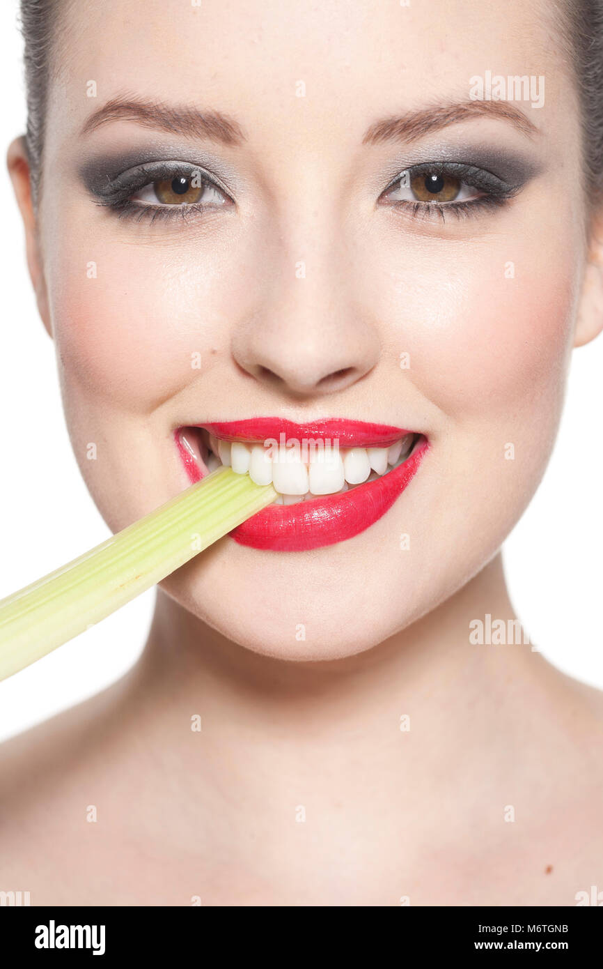 Woman biting into celery Stock Photo