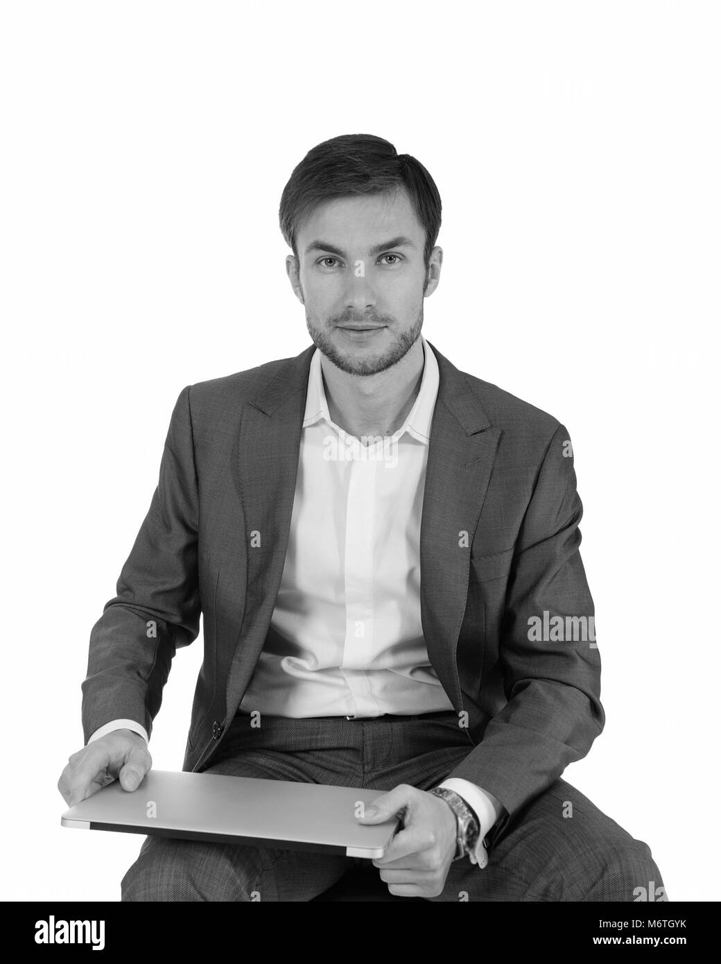 Businessman with laptop looking away. Light background. Black and white