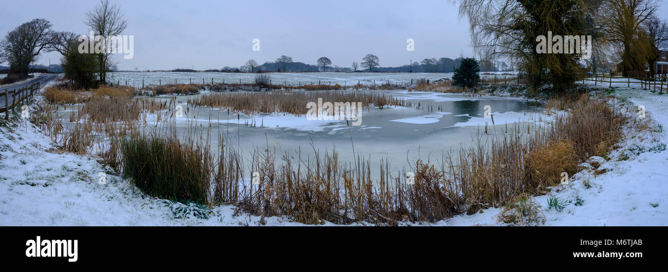 Large and high resolution panorama - Winter snow scene frozen farm pond - near St Nicholas church, South Boarhunt, Hampshire, UK Stock Photo