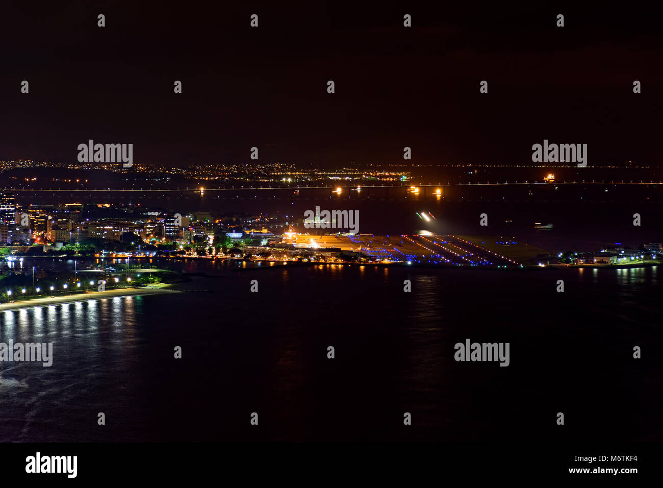 Night view of the top of the Santos Dumont airport at downtown of Rio de Janeiro with lights, buildings and Rio Niteroi bridge at background Stock Photo