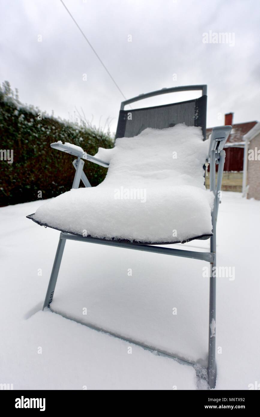 Outdoor patio garden chair covered in snow Stock Photo Alamy