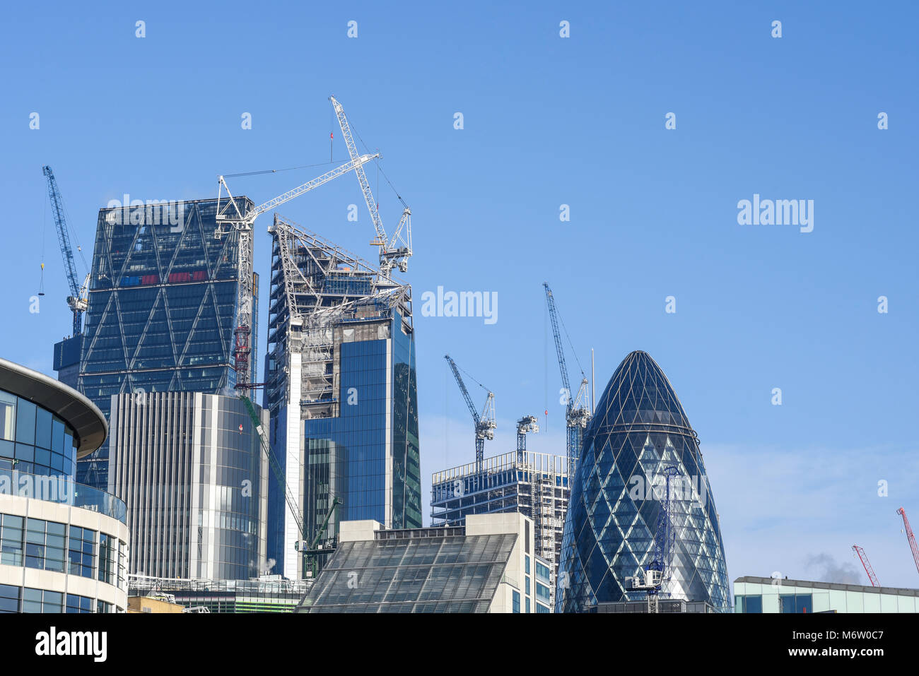 Construction cranes on London skyline in the City of London. The Scalpel Gherkin Cheesegrater Leadenhall Building Stock Photo