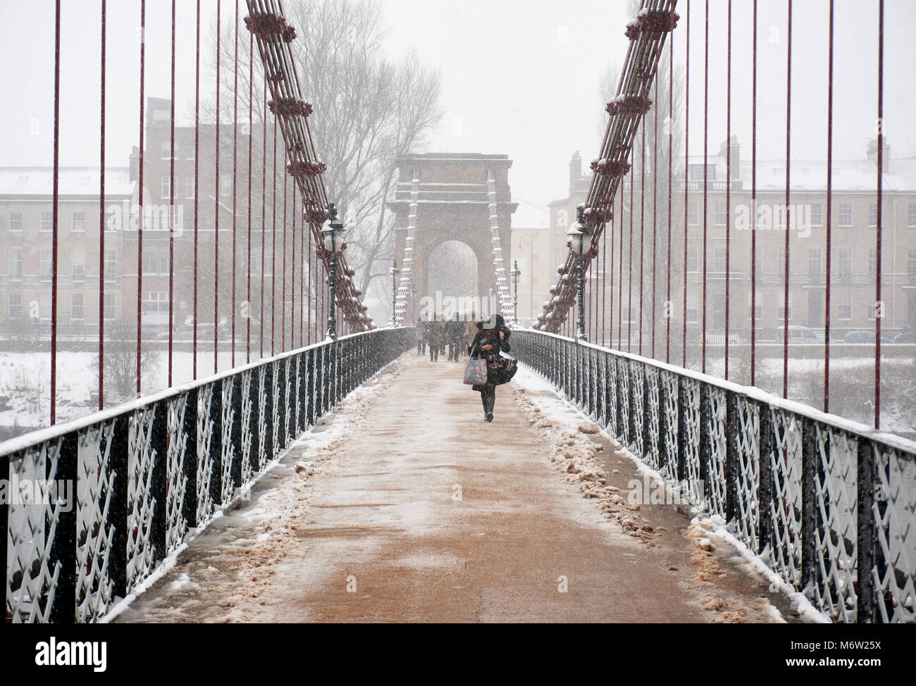 South Portland Street suspension bridge over the river Clyde covered in snow following the 'beast from the east' storm, Glasgow, Scotland. Stock Photo