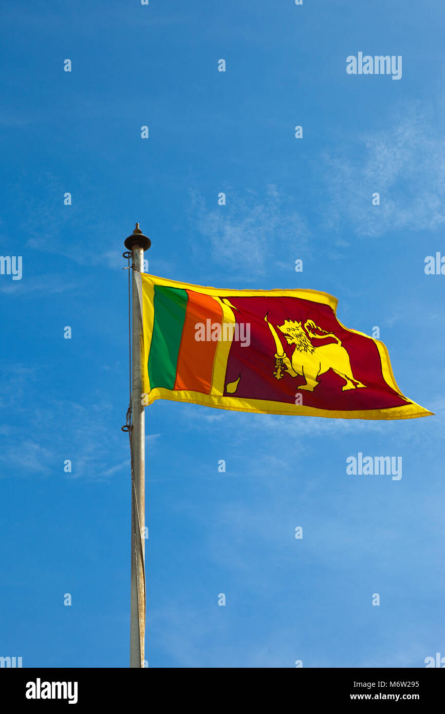 beautiful colorful sri lankan flag with flag pole against a blue sky at mount lavinia in colombo Stock Photo