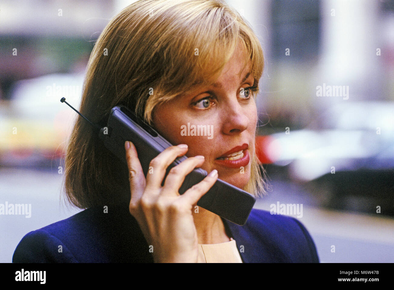1996 HISTORICAL CAUCASIAN BUSINESS  WOMAN OUTDOORS WITH MOBILE CELLULAR TELEPHONE (©MOTOROLA CORP 1995) Stock Photo