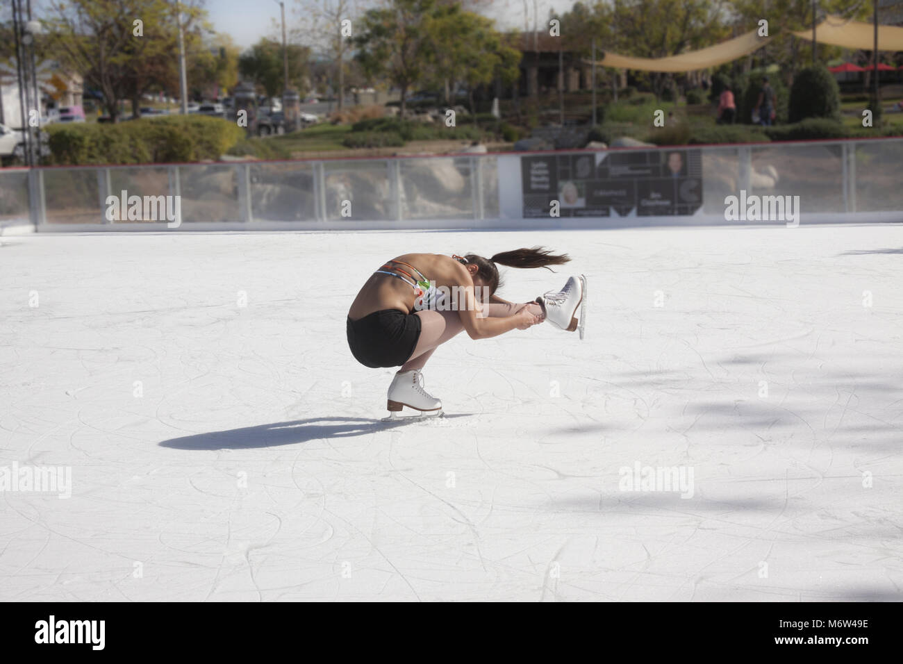 Teenage girl ice skating outdoors in shorts and a bikini top in Southern Califiornia in 85