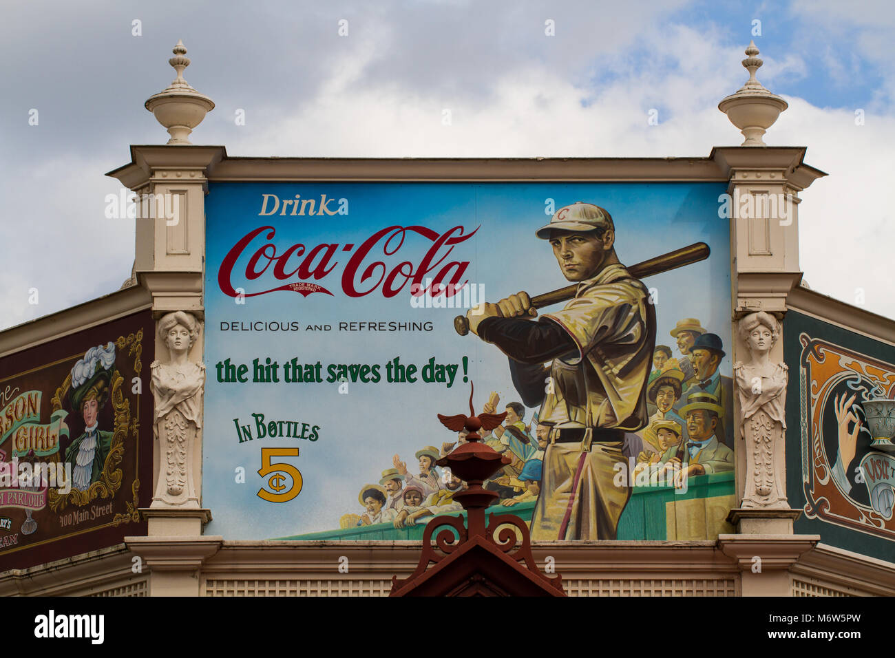 A large billboard with an old fashioned, vintage Coca Cola advertisement showing a baseball Star and Coke slogan. Stock Photo