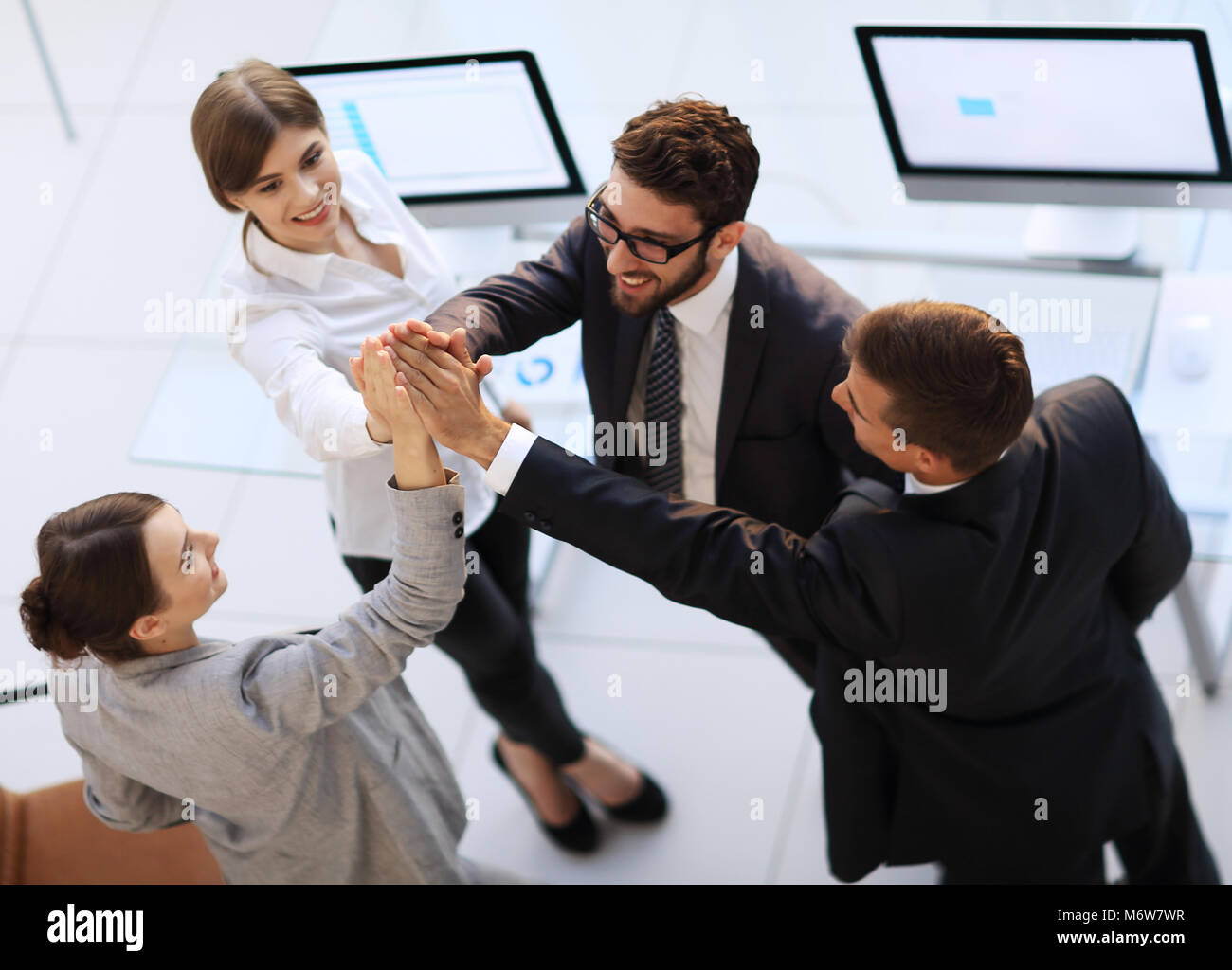 successful business team giving each other a high-five, standing in the ...