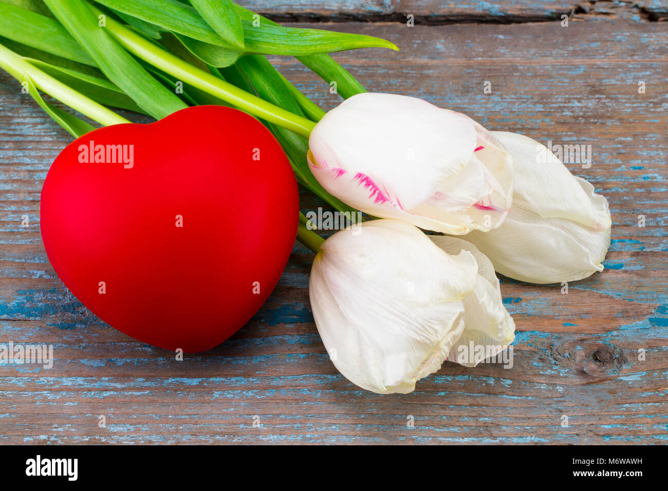 Colorful tulips and Valentine's day hearts on wooden background. Stock Photo