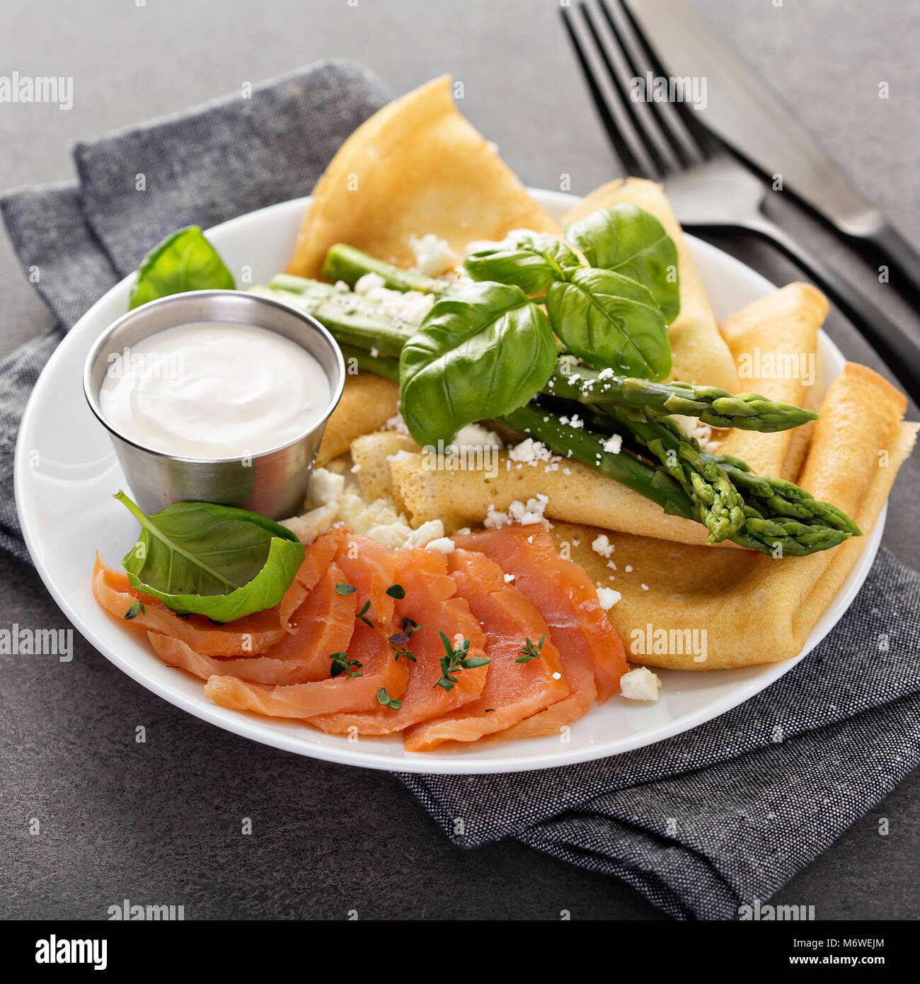Savory crepes with salmon, sour cream, feta and asparagus Stock Photo