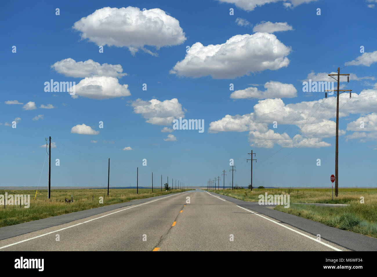 Paved road with posts on sides during bright day Stock Photo