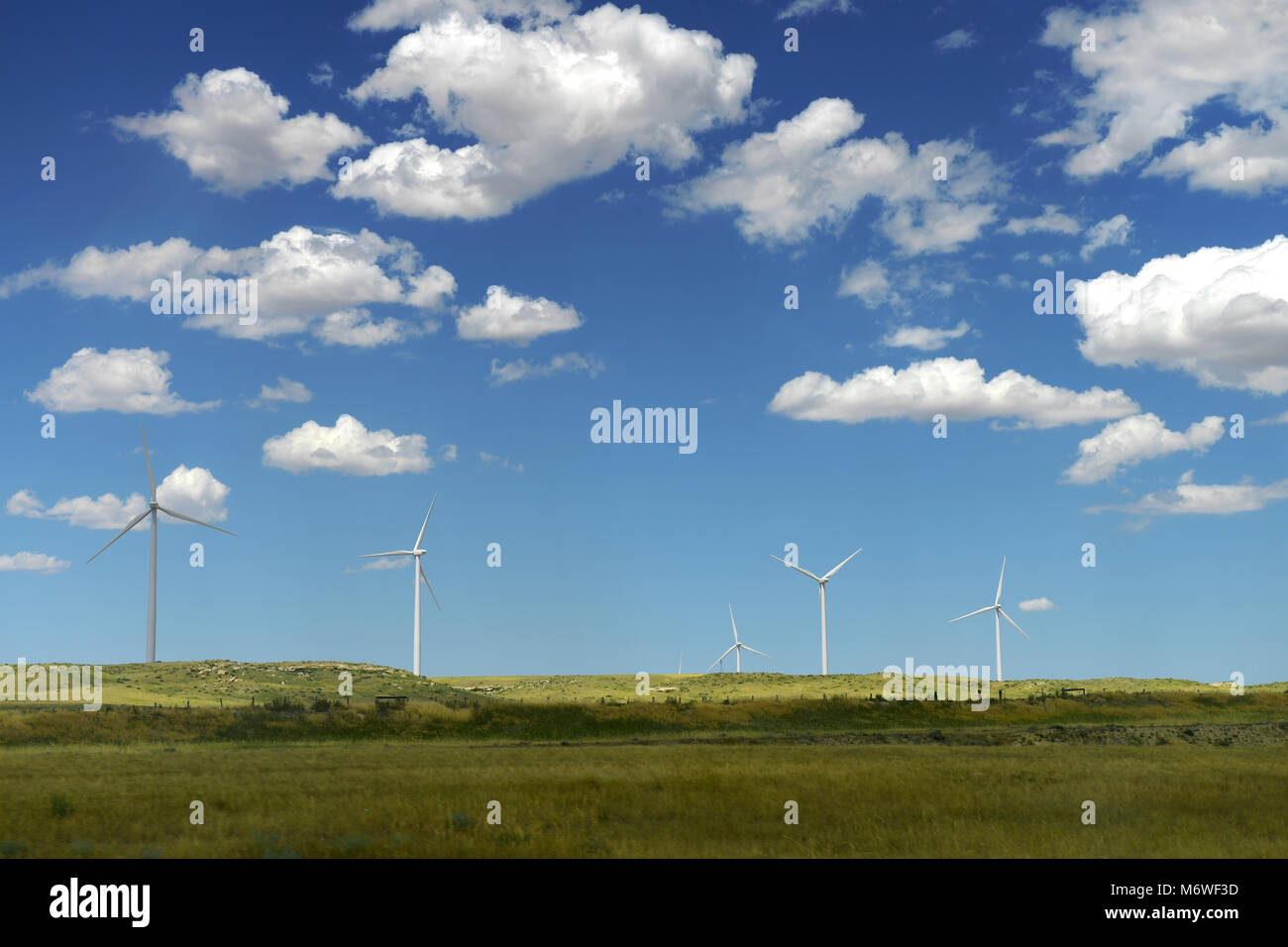 Wind turbines in open field during bright day Stock Photo