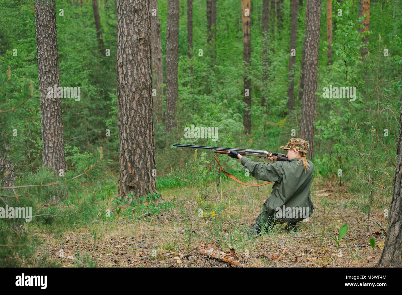 Woman hunter with a gun. Hunting in the woods Stock Photo - Alamy