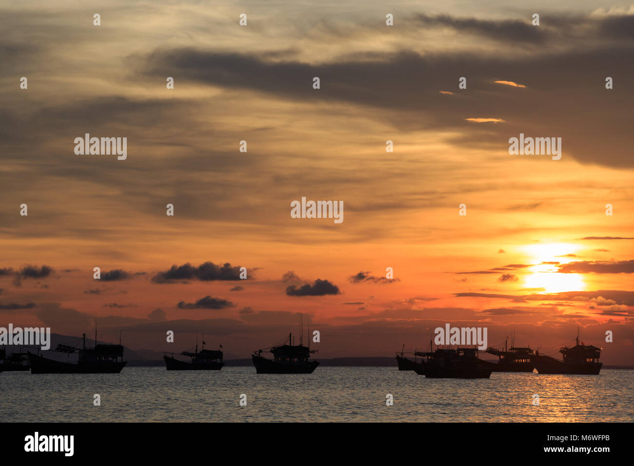 Vietnamese fishing boat silhouettes in sea at sunset Stock Photo - Alamy
