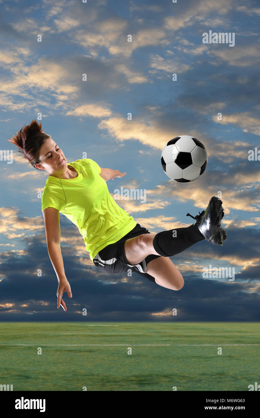 Female soccer player kicking ball outdoors at dusk Stock Photo Alamy