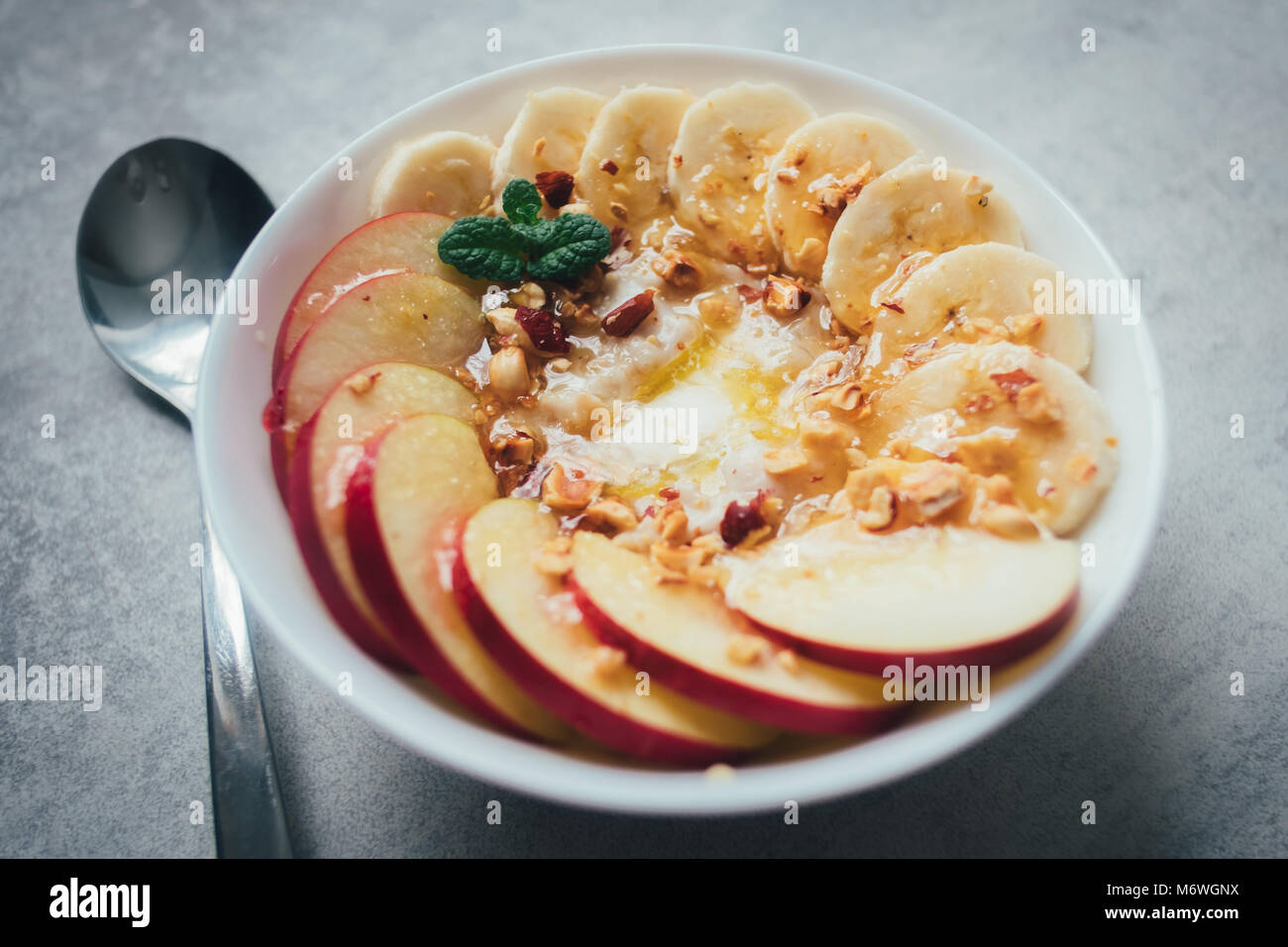 Oatmeal with banana, dried nuts and honey Stock Photo