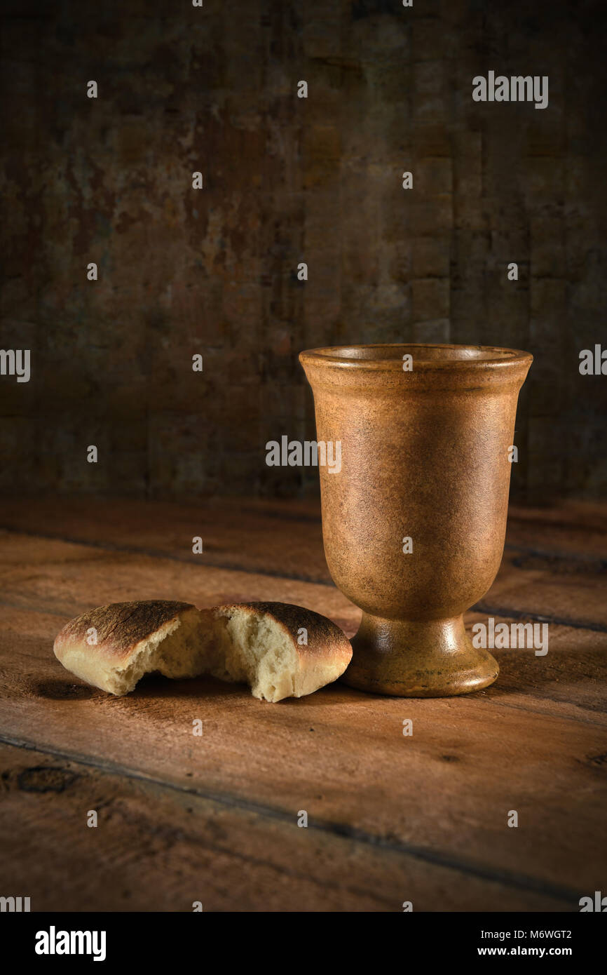 Communion wine cup and bread on wooden table Stock Photo