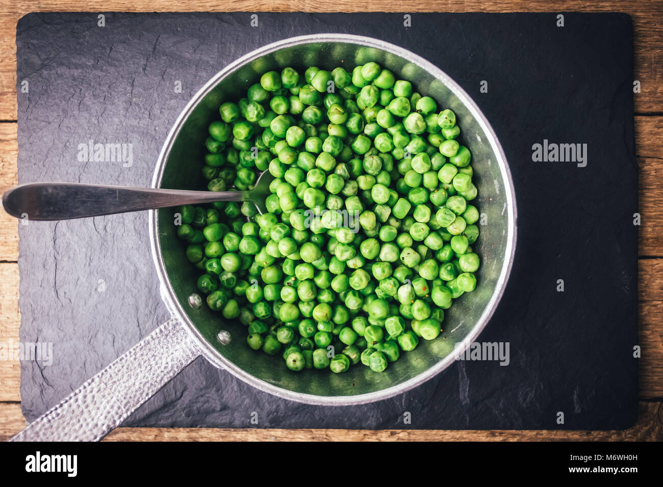 Green peas on silver frying pan Stock Photo
