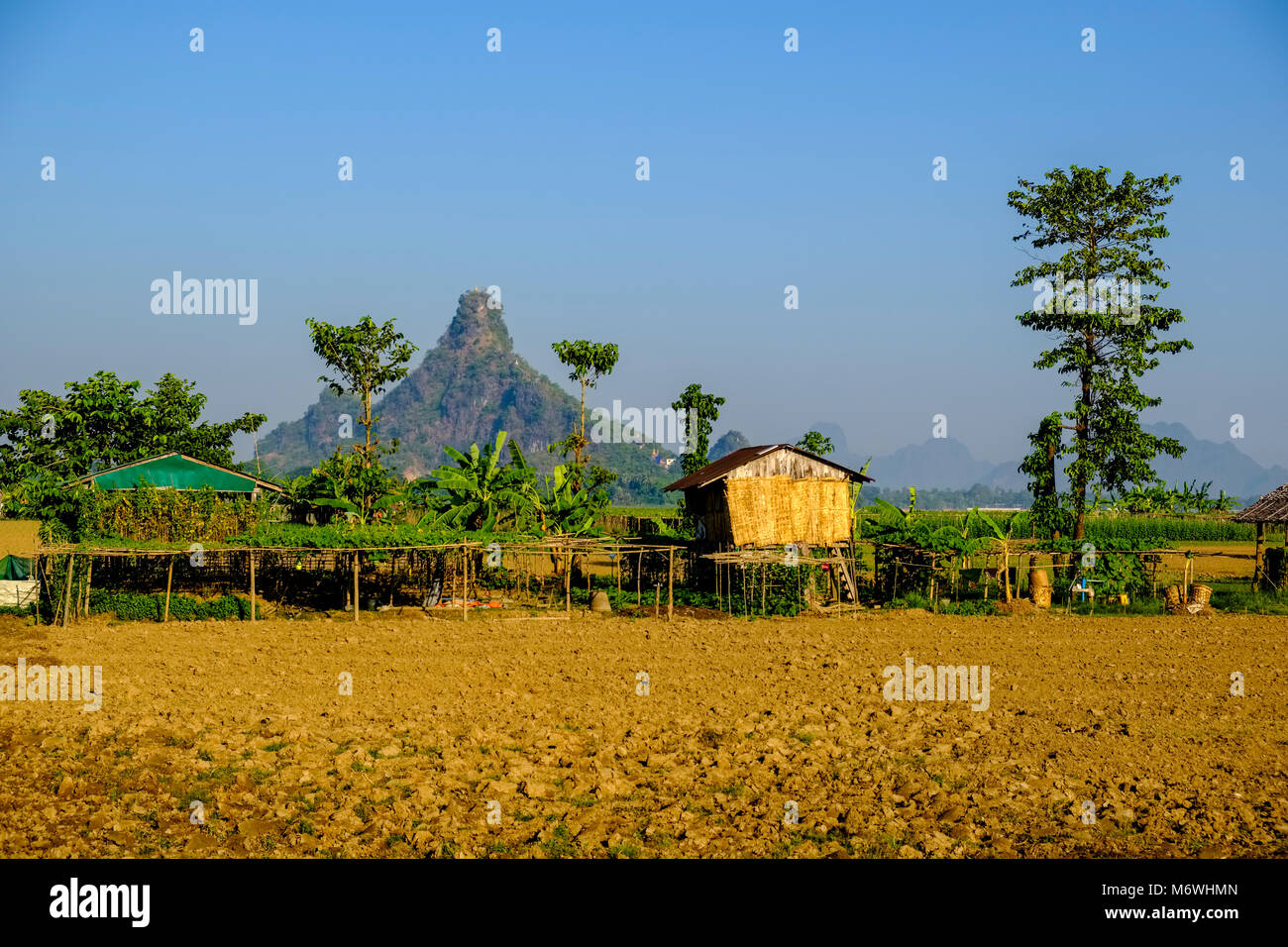 Agricultural landscape with farmers huts and Hpa-Pu hill in the distance Stock Photo