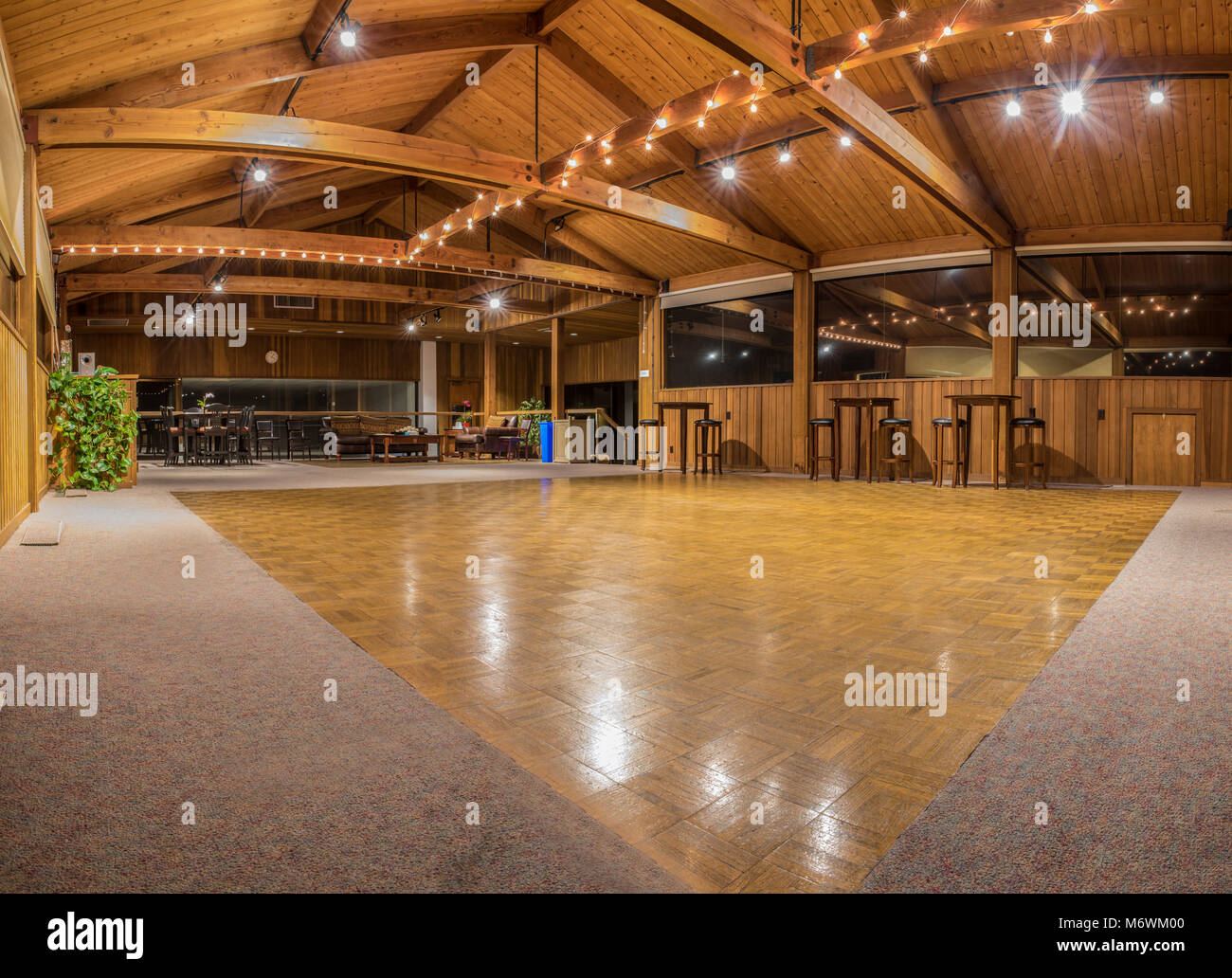 Exquisite wood floor and vaulted ceiling interior of dance hall party room with sparkling lights.  Pierpont Racquet Club of Ventura, California 2018. Stock Photo