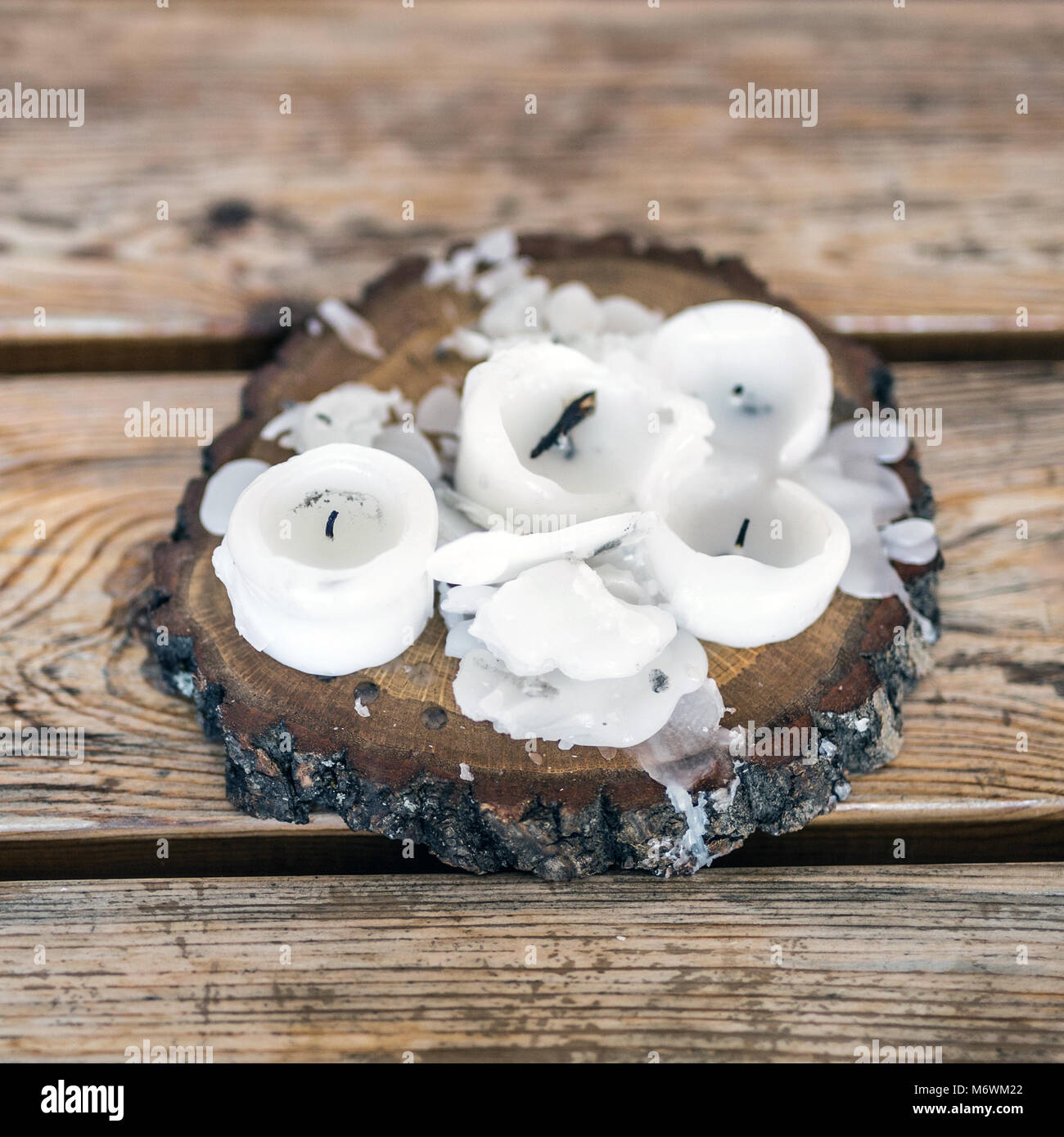 Burnt candles with melted wax on a wooden candlestick standing over