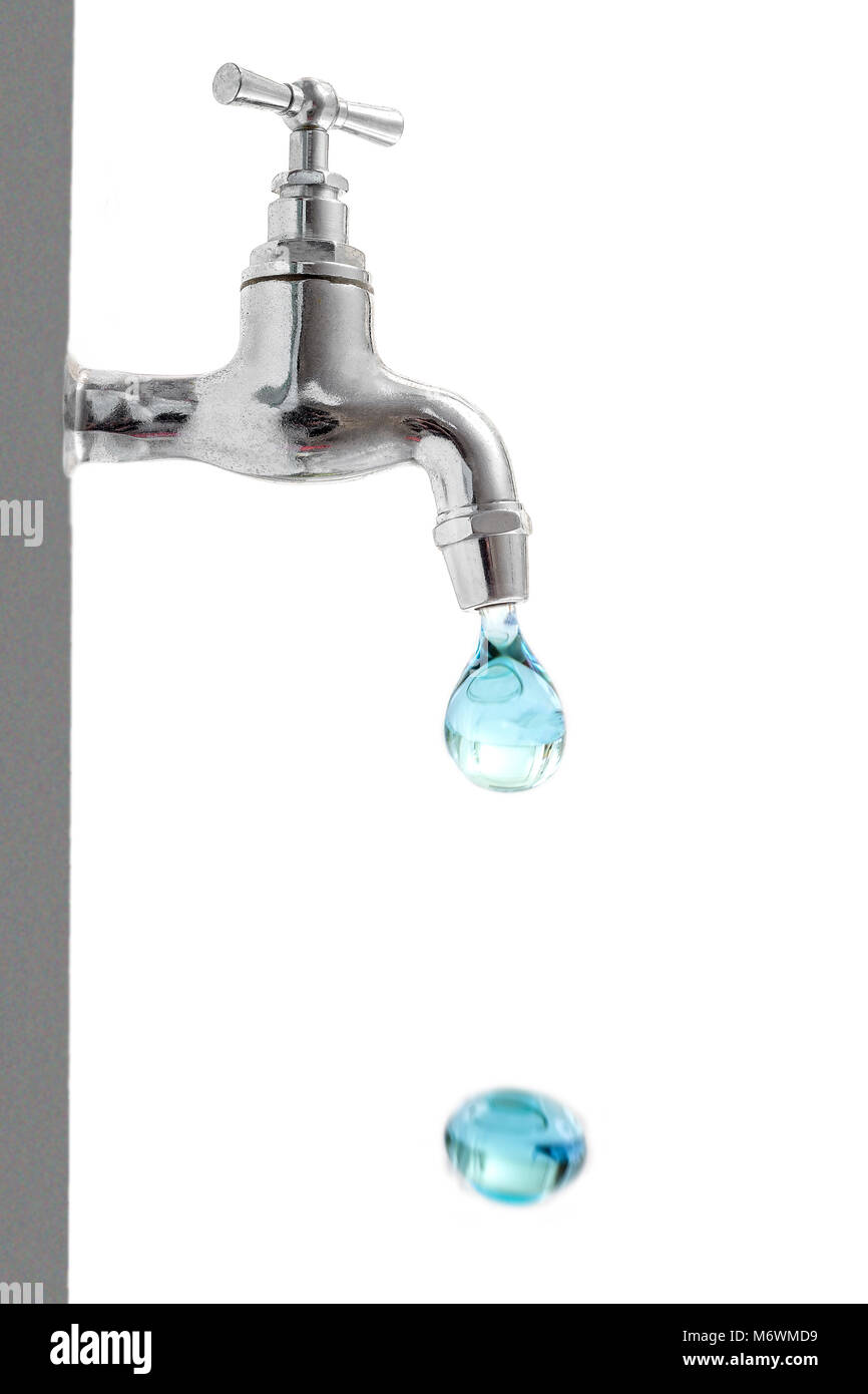 vertical image of a drop of water falling from a tap, with another on the ground, on a white background. Space for text on the right space. Stock Photo