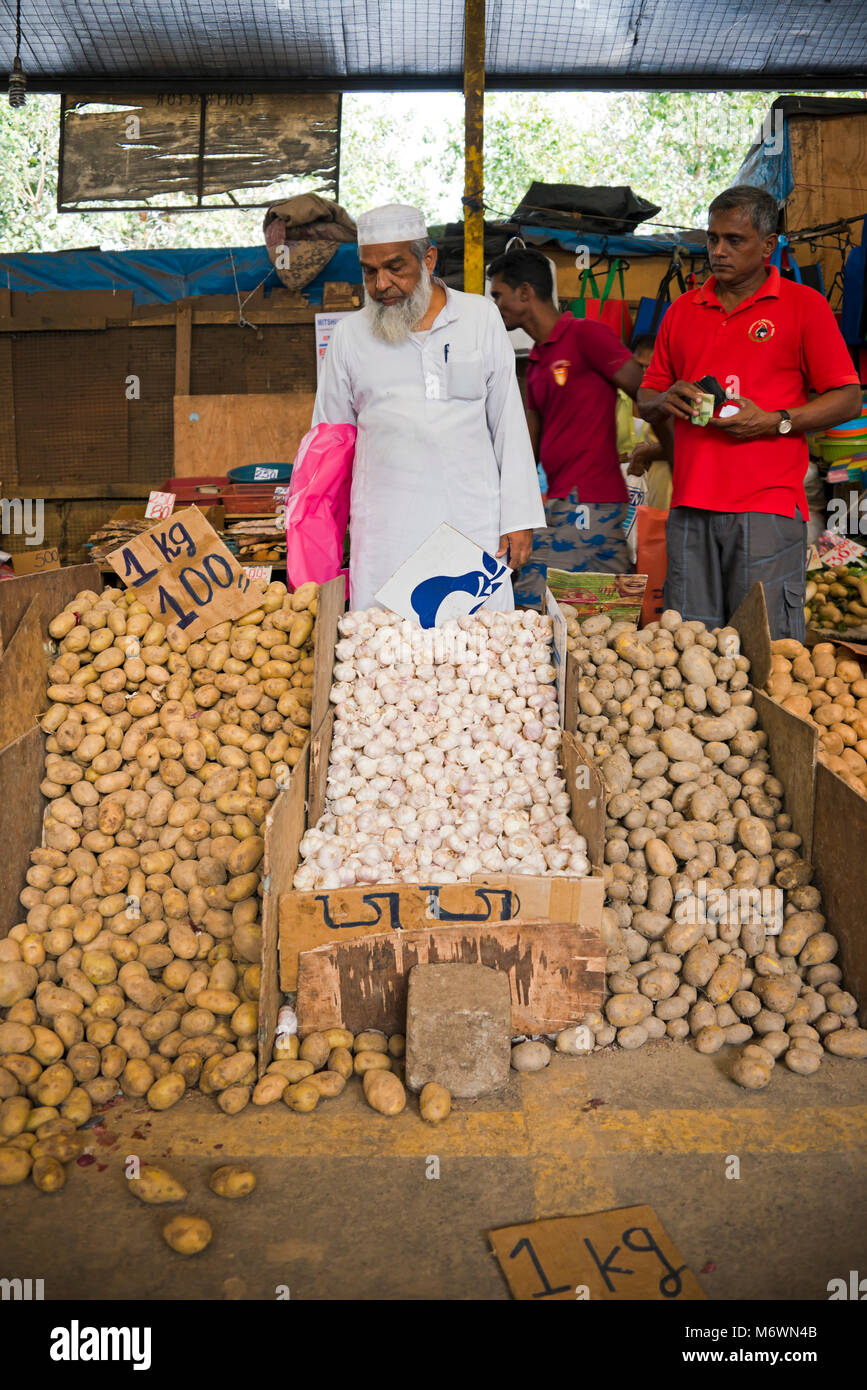 Vertical view of a Muslim man selling potatoes and garlic at Pettah market in Colombo, Sri Lanka. Stock Photo