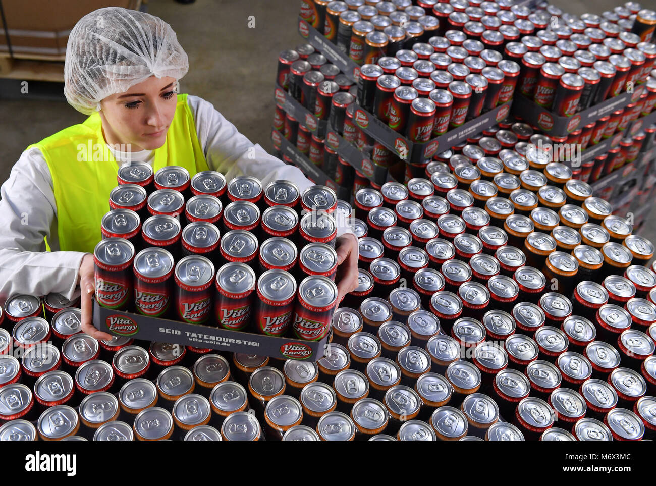 10 February 2018, Germany, Lichtenau: Verena Schmidt, employee of Lichtenauer Mineralquellen GmbH, loading boxes of Vita Energy cans onto a pallet. The launch of two new varieties of Vita Energy in the eastern German market is planned for March 2018. Twelve alcohol-free refreshment drinks are now available under the Vita Cola brand. Photo: Martin Schutt/dpa-Zentralbild/dpa Stock Photo