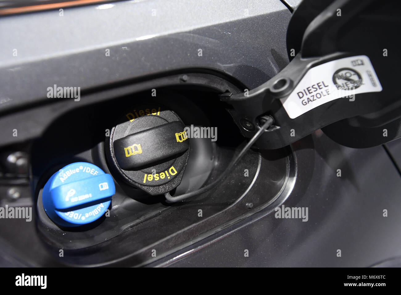 07 March 2018, Switzerland, Geneva: A filler plug for a diesel tank is on  display right next to a AdBlue filler plug (L) on an Volkswagen (VW) Diesel  Golf Alltrack 2.0 TDI