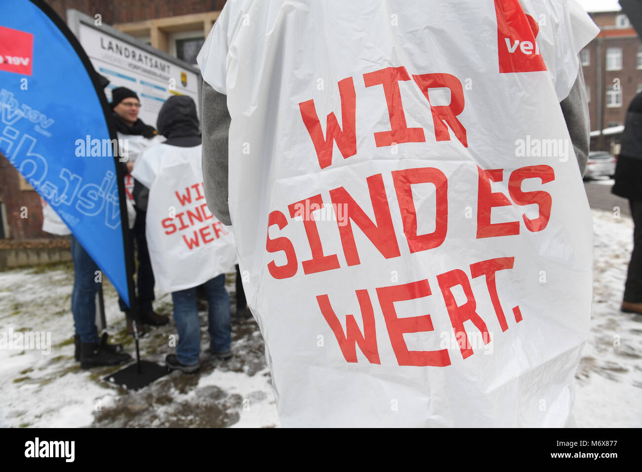 07 March 2018, Germany, Stralsund: The writing on the bib reads 'We are worth it' as public service staff gather in front of the district office of county Western Pomerania and Ruegen for a warning strike. The first round of wage and salary negotiations for the nationwide 2, 3 million public service emplyees has ended without an offer from public service employers more than a week ago. Photo: Stefan Sauer/dpa Stock Photo