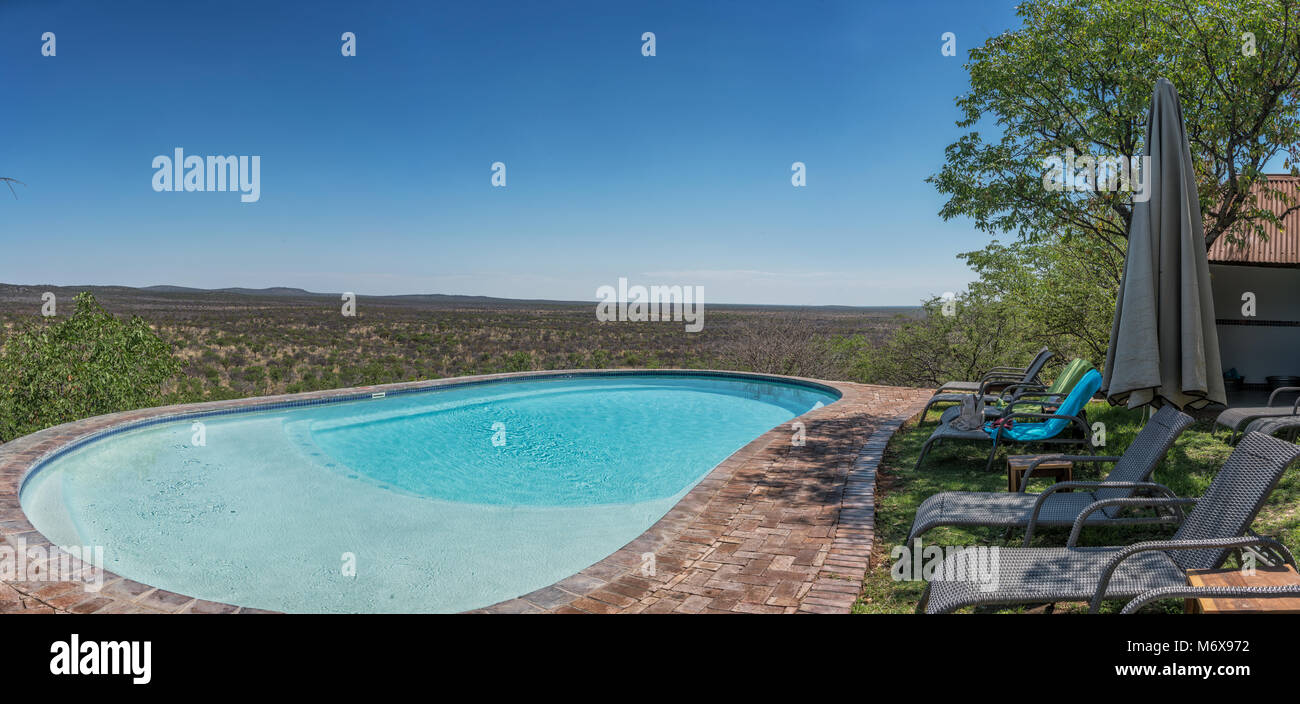 Pool with chairs overlooking the Namibian African savannah. Stock Photo