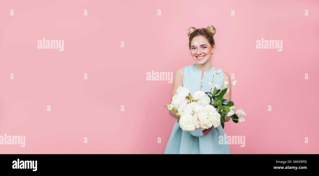 Beautiful woman with a bunch of flowers on a pink Stock Photo
