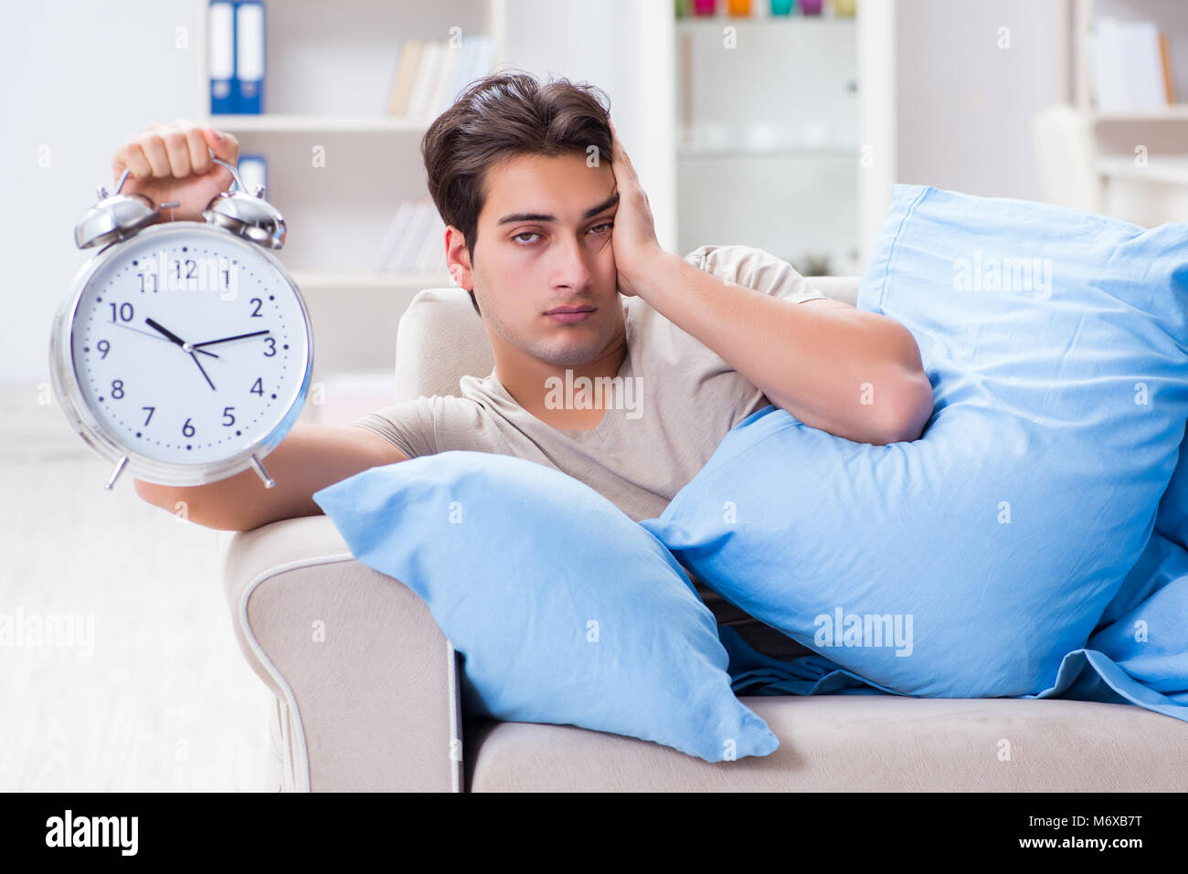 Man having trouble waking up with alarm clock Stock Photo Alamy