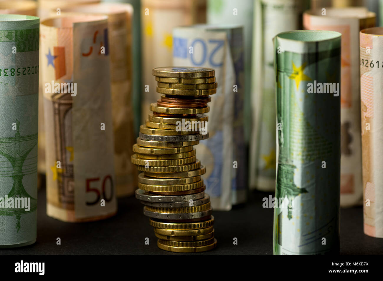 Stack of euro coins and rolls of bank notes in the background Stock ...