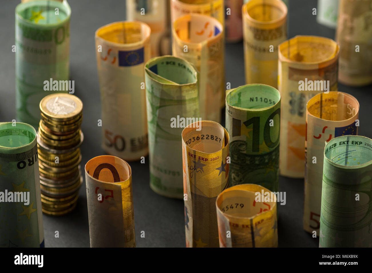 Stack of euro coins and rolls of bank notes in the background Stock ...