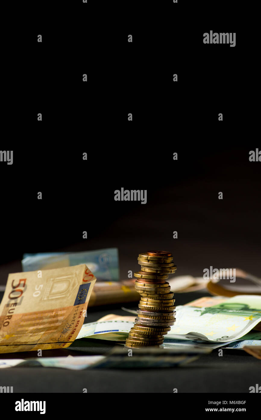 Stack of euro coins and banknotes in a black background Stock Photo - Alamy